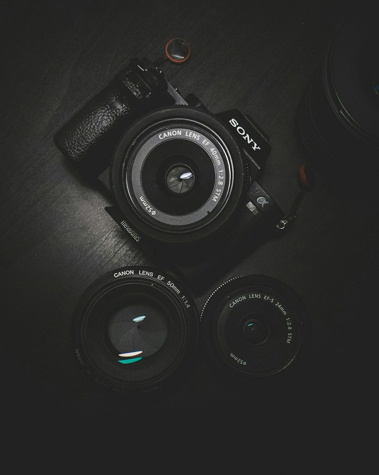 Camera body and lenses on a dark table